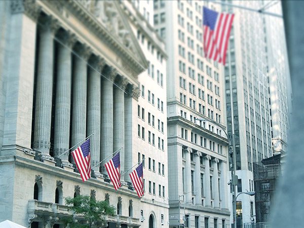 New York City, United States. Lower Manhattan Downtown Financial District urban architecture exterior. American flag. Wall street Stock Exchange building facade columns, USA Stock Market trading, NYC